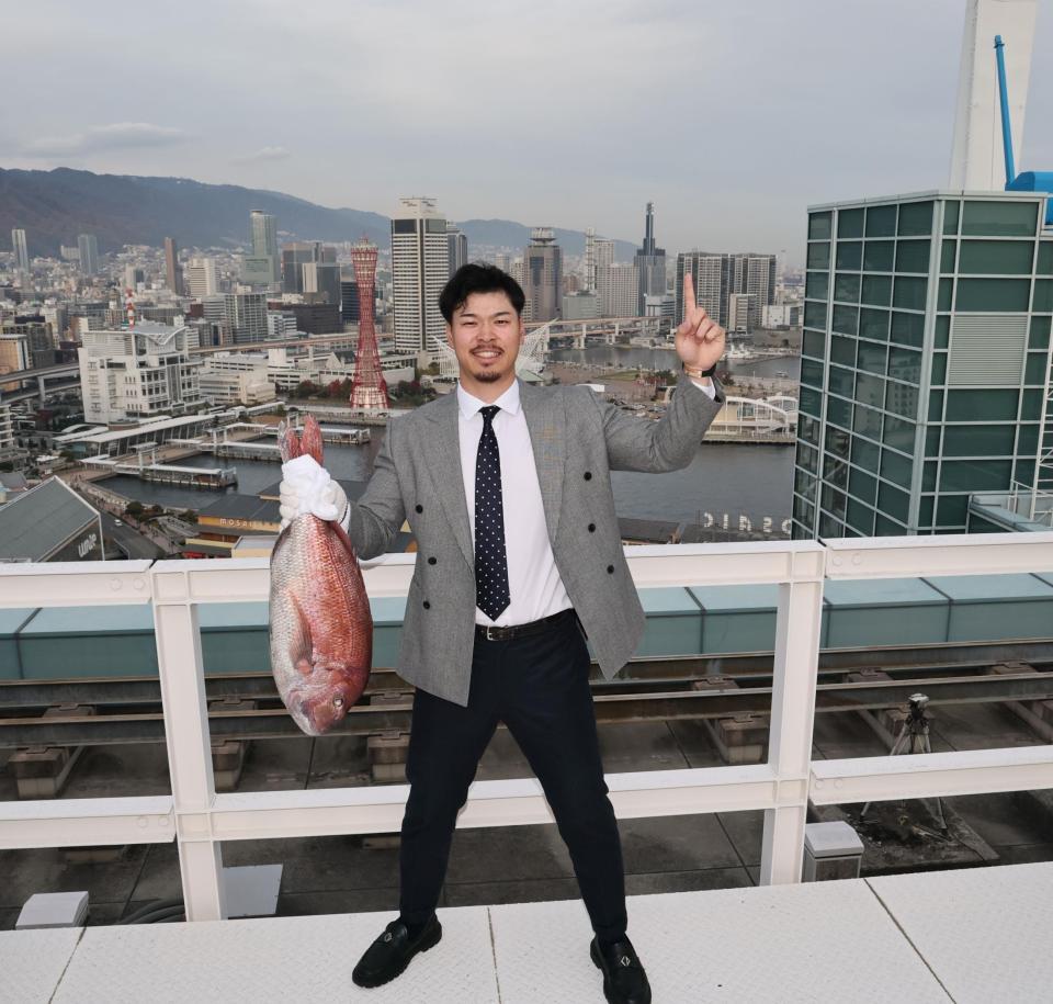 　神戸の街から日本一へ！！ 鯛を手にポーズを決める佐藤輝（撮影・田中太一）
