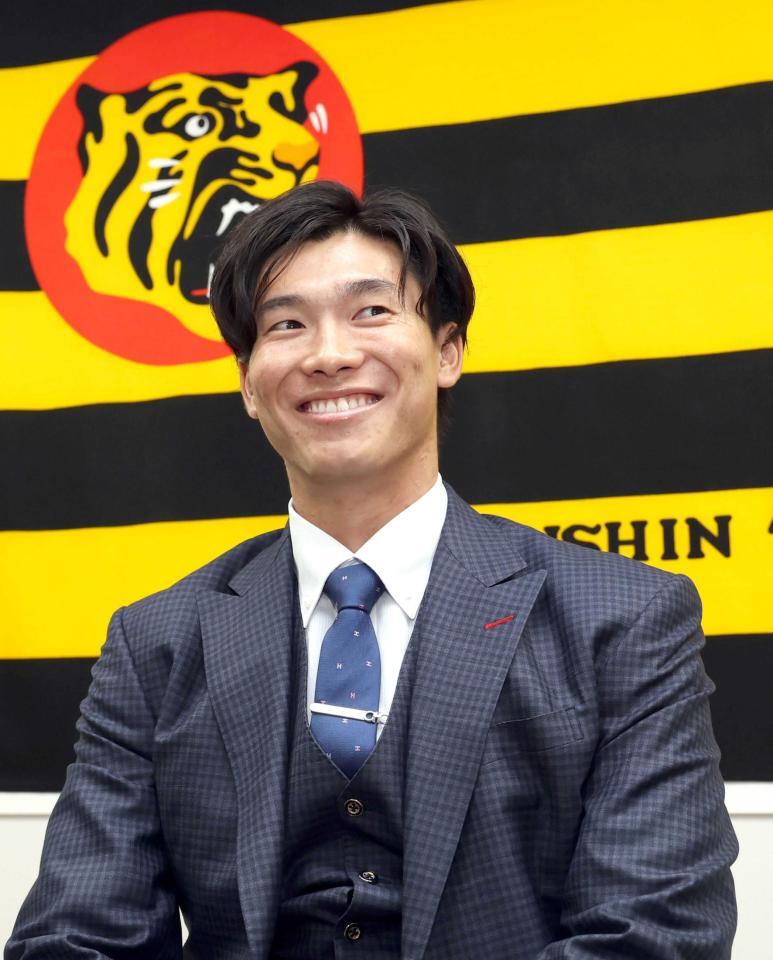 　契約を更改し、会見で笑顔を見せる湯浅（撮影・山口登）