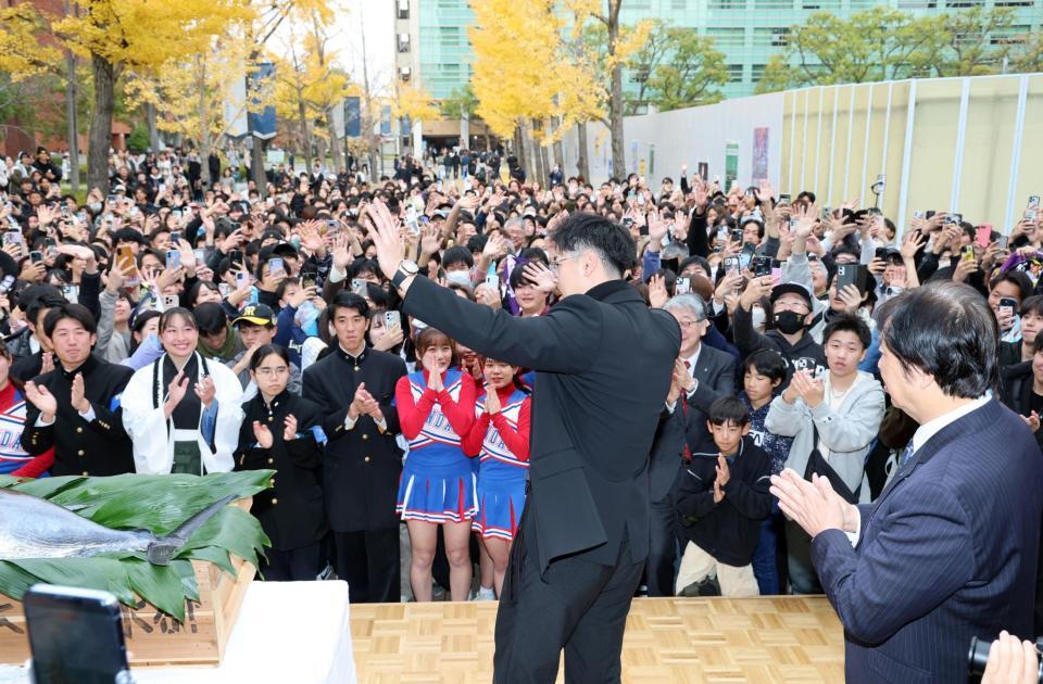 　集まった学生らに手を振り降壇する佐藤輝（撮影・山口登）