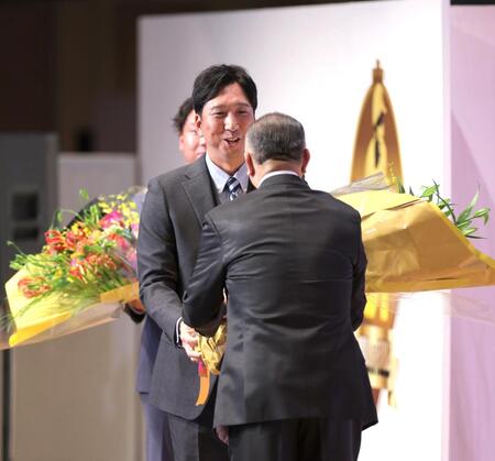 　掛布ＯＢ会長（右）に花束を手渡す藤川監督（撮影・北村雅宏）