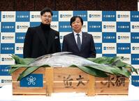 　近大マグロを贈られ、写真に納まる佐藤輝（左）と近大・松村到学長（撮影・山口登）