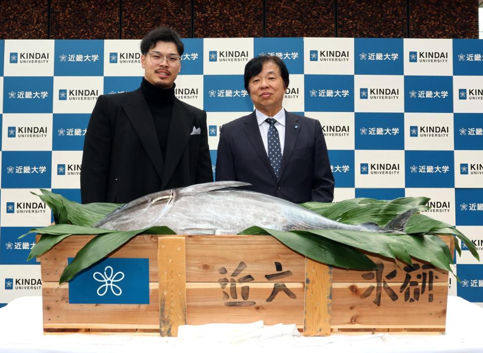 　近大マグロを贈られ、写真に納まる佐藤輝（左）と近大・松村到学長（撮影・山口登）