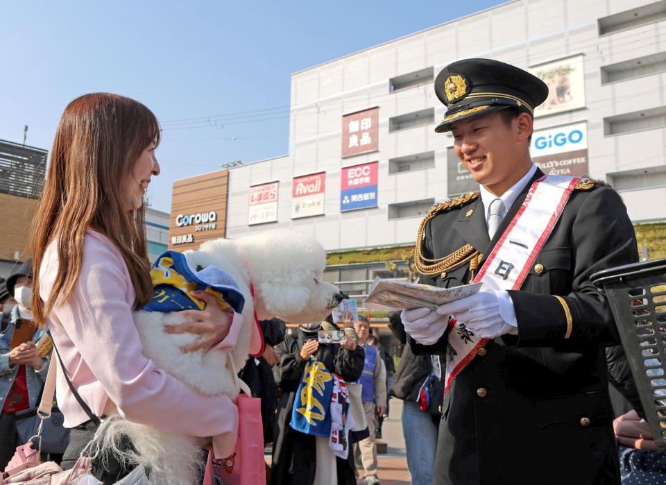 　甲子園警察署の一日署長を務め、啓発グッズを配布する伊原（右）＝撮影・北村雅宏