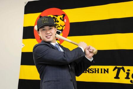 　入団会見でポーズを決める浜田（撮影・山口登）