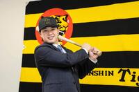 　入団会見でポーズを決める浜田（撮影・山口登）