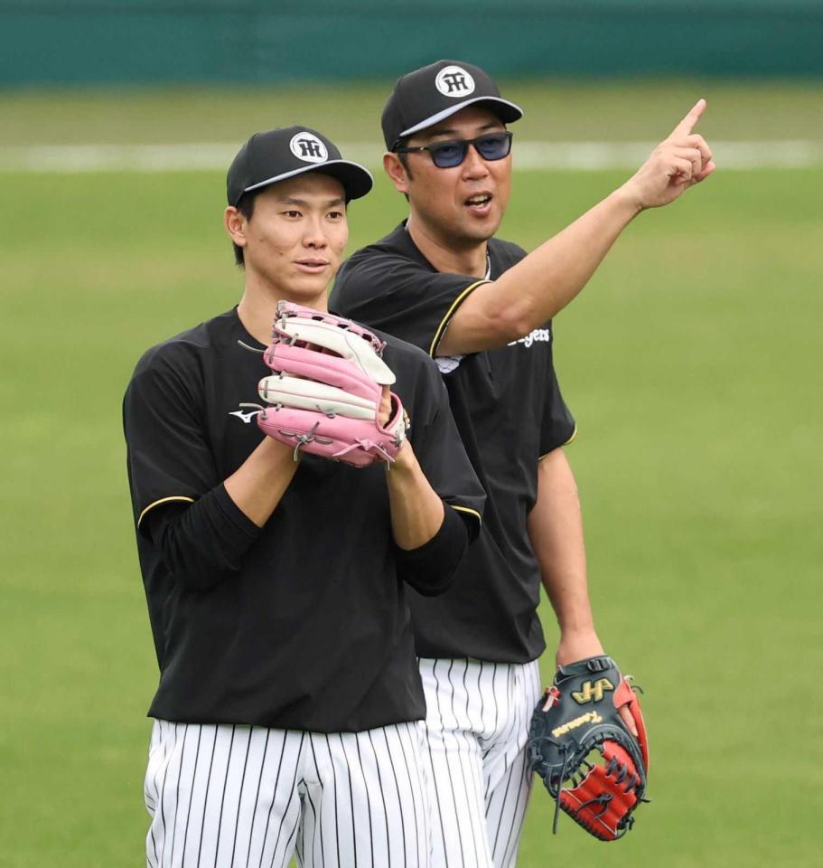 　金村投手コーチ（右）と話す湯浅＝５月２日