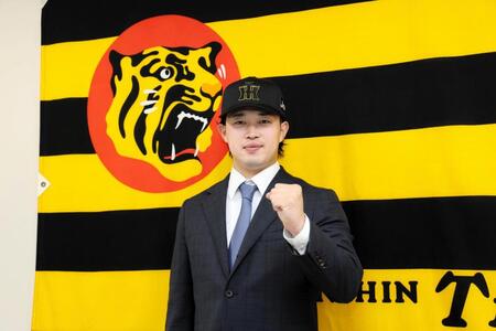 　入団会見でポーズを決める浜田（撮影・山口登）