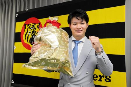 　契約を更改し、笑顔でポーズを決める（撮影・山口登）