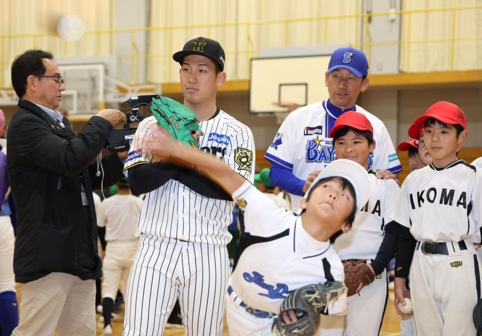 　三浦大輔氏（奥）と子どものピッチングを見つめる伊原（撮影・中田匡峻）