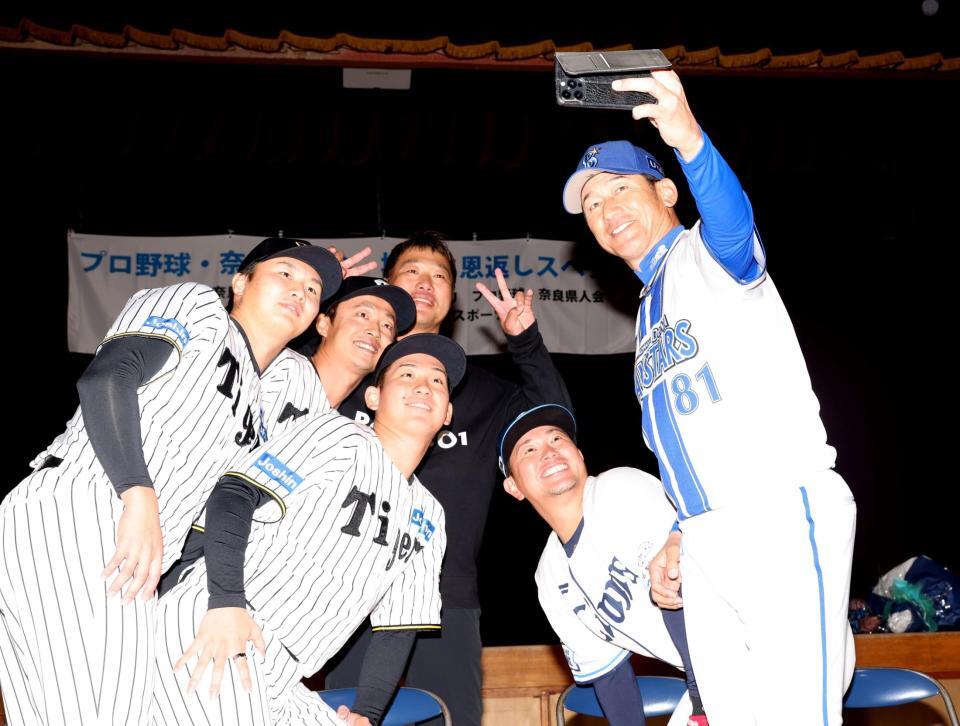 　三浦大輔氏（右）の“番長フレーム”で写真撮影をする（左から）津田、島本、伊原、関本賢太郎氏、岡田雅利氏（撮影・中田匡峻）