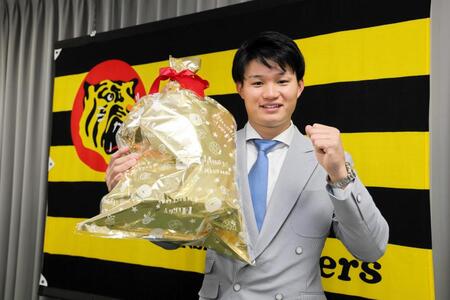 　契約を更改した森下はクリスマスプレゼントを抱え笑顔でポーズ（撮影・山口登）