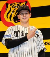 　ポーズを決めるドラフト５位の能登嵩都（撮影・山口登）