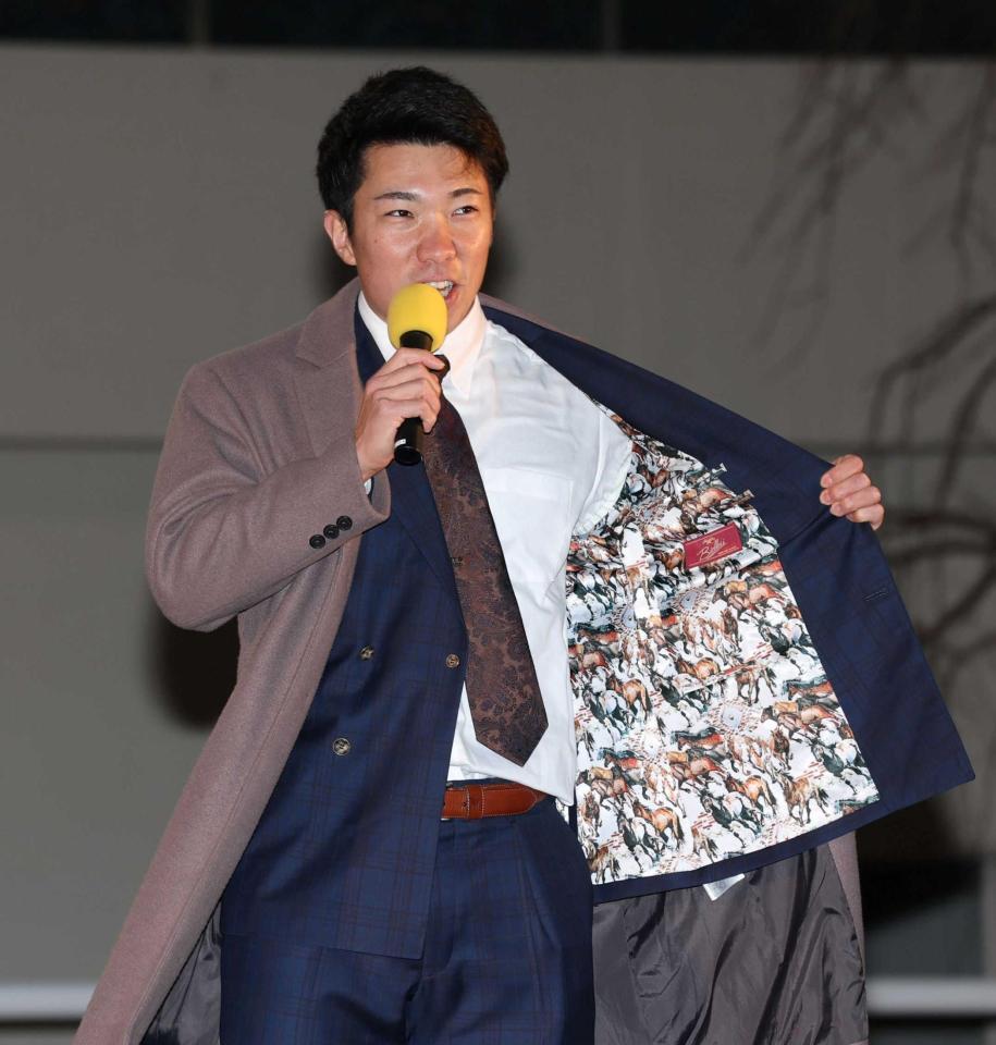 　レース後のトークショーで馬が刺繍されたスーツの裏地を披露する石井（撮影・中田匡峻）