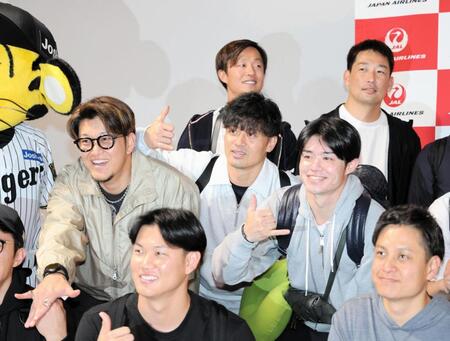 　優勝旅行出発前、写真に納まる坂本（中央）ら阪神ナイン（撮影・山口登）