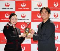 　客室乗務員から記念品を送られる村上（右）＝撮影・山口登