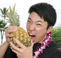 　パイナップルにかぶりつく石井（撮影・田中太一）