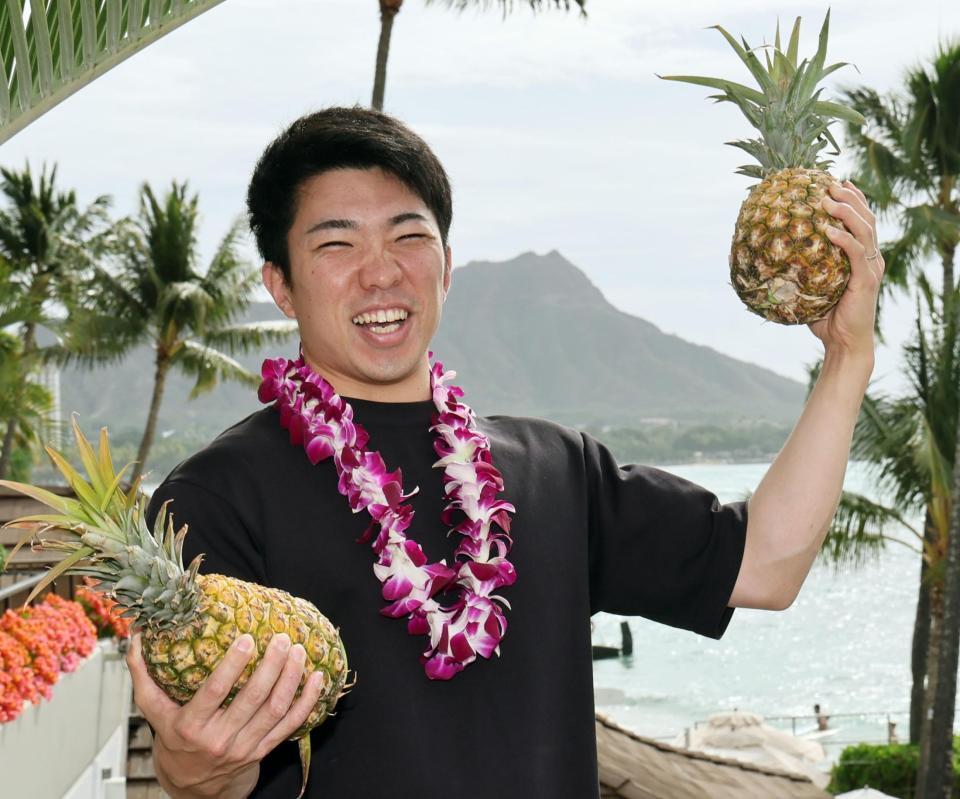 　パイナップルを持ち上げる石井（撮影・田中太一）