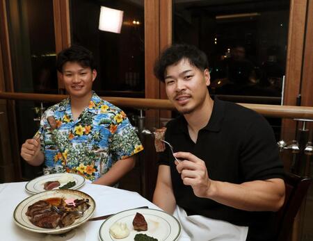 　肉料理を楽しむ佐藤輝（右）と森下（撮影・田中太一）