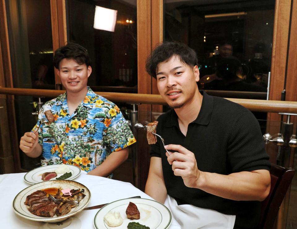 　肉料理を楽しむ佐藤輝（右）と森下（撮影・田中太一）