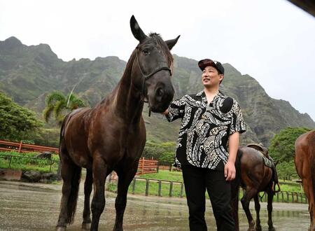 　雄大な山を背に、馬を見つめる岩崎（撮影・田中太一）