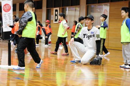 　子どもの打撃を笑顔で見つめる今朝丸