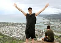 　頂上にたどり着き、ホノルル市街を背に両手を上げる大竹（撮影・田中太一）