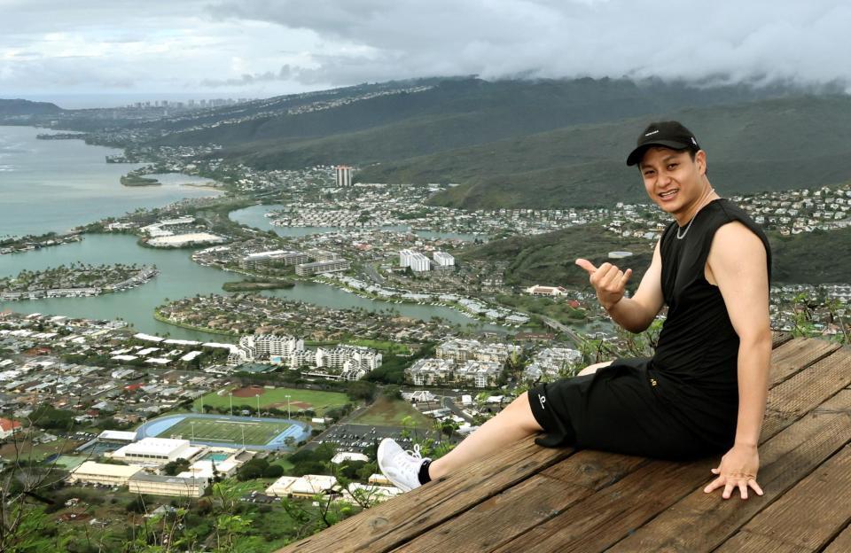 　頂上付近の展望デッキに座り、ホノルル市街を見下ろす大竹（撮影・田中太一）