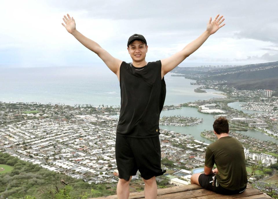 　頂上にたどり着き、ホノルル市街を背に両手を上げる大竹（撮影・田中太一）