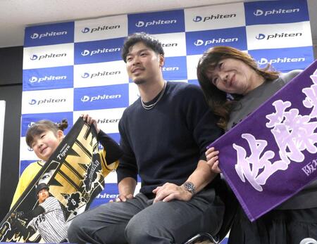 　ファンと写真に納まる佐藤輝（中央）＝撮影・北村雅宏
