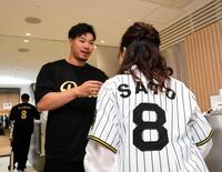 　ＲＵＥＬＬＥ大阪堀江店で１日店長を務めた佐藤輝は来店者にサインする（撮影・山口登）