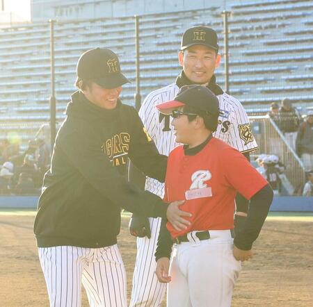 　子どものおなかをさわる高橋（左）。笑顔の岩崎（撮影・佐々木彰尚）