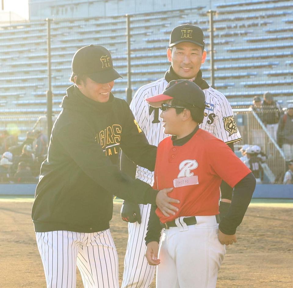 　子どものおなかをさわる高橋（左）。笑顔の岩崎（撮影・佐々木彰尚）