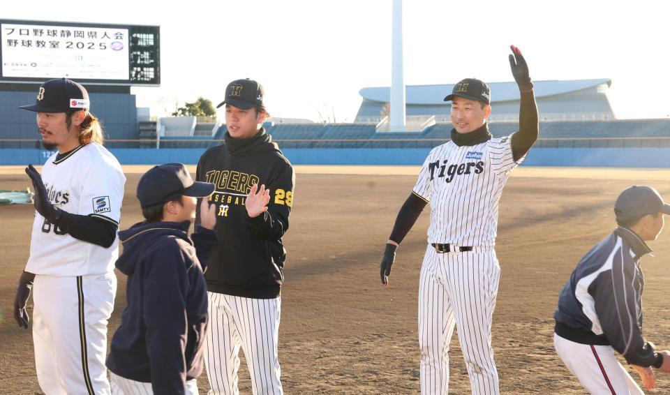 　子どもたちとタッチする高橋（中央）と岩崎（右）＝撮影・佐々木彰尚
