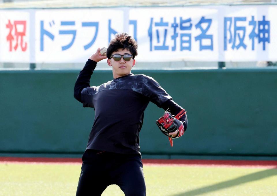 　横断幕を背にキャッチボールをする立石（撮影・田中太一）