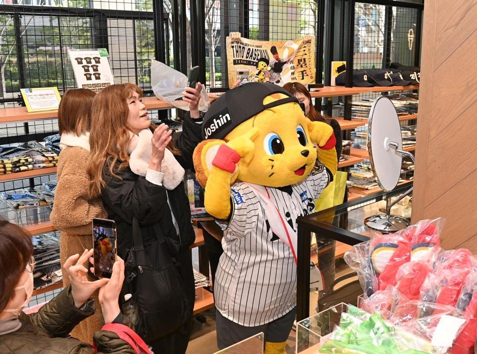 　タイガースショップの来店客と写真を撮るキー太（撮影・西田忠信）