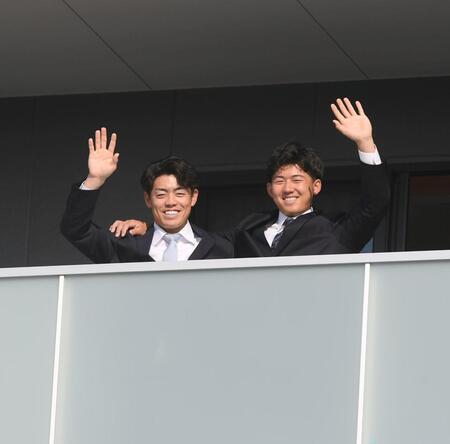 　入寮しベランダから手を振る谷端（左）と立石（撮影・西田忠信）