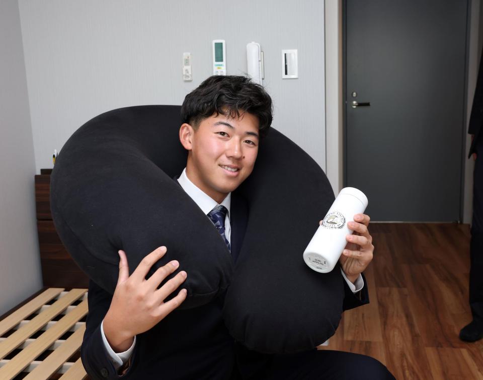 　ヨギボーを首に巻いてタンブラーを持つ立石