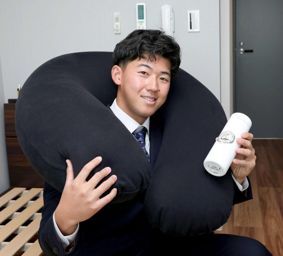 　ヨギボーを首に巻いてタンブラーを持つ立石