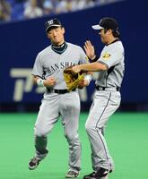 　中日に会心の勝利し、葛城（右）とおどけながらタッチする金本