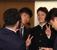 ロッテ・奥村（右）と写真を撮る阪神・立石（撮影・佐々木彰尚）