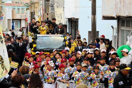 パレードカーに装飾されたトラックの荷台に乗り「みじらしゃ通り商店街」を走る近本