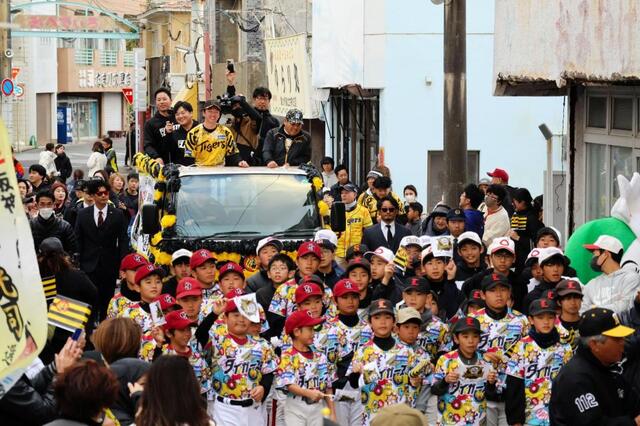 パレードカーに装飾されたトラックの荷台に乗り「みじらしゃ通り商店街」を走る近本
