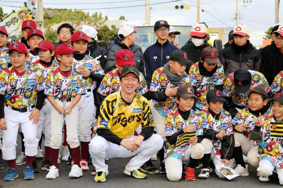 パレードカー前に先導する地元野球少年らと写真撮影する近本
