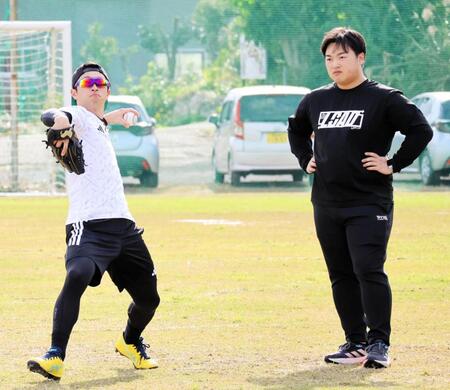 自主トレでキャッチボールをする近本（写真左）と植松トレーナー（同右）＝沖永良部島