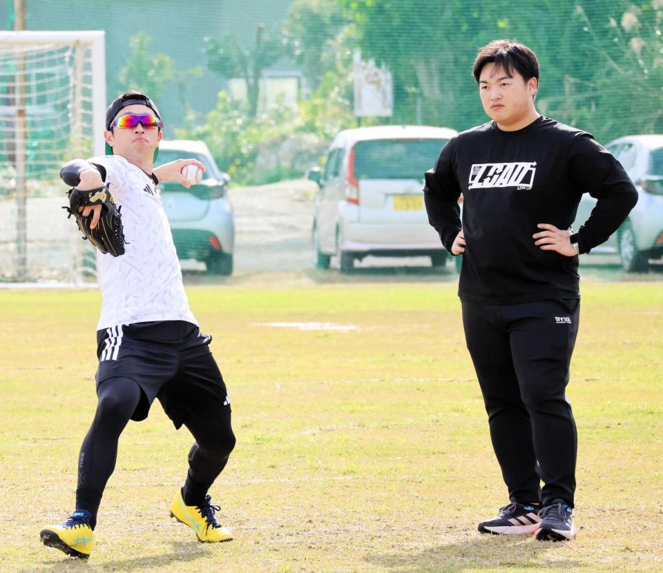 自主トレでキャッチボールをする近本（写真左）と植松トレーナー（同右）＝沖永良部島