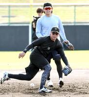 ノックを受ける阪神・梅野隆太郎。奥は日本ハム・清水優心＝宜野座（撮影・田中太一）