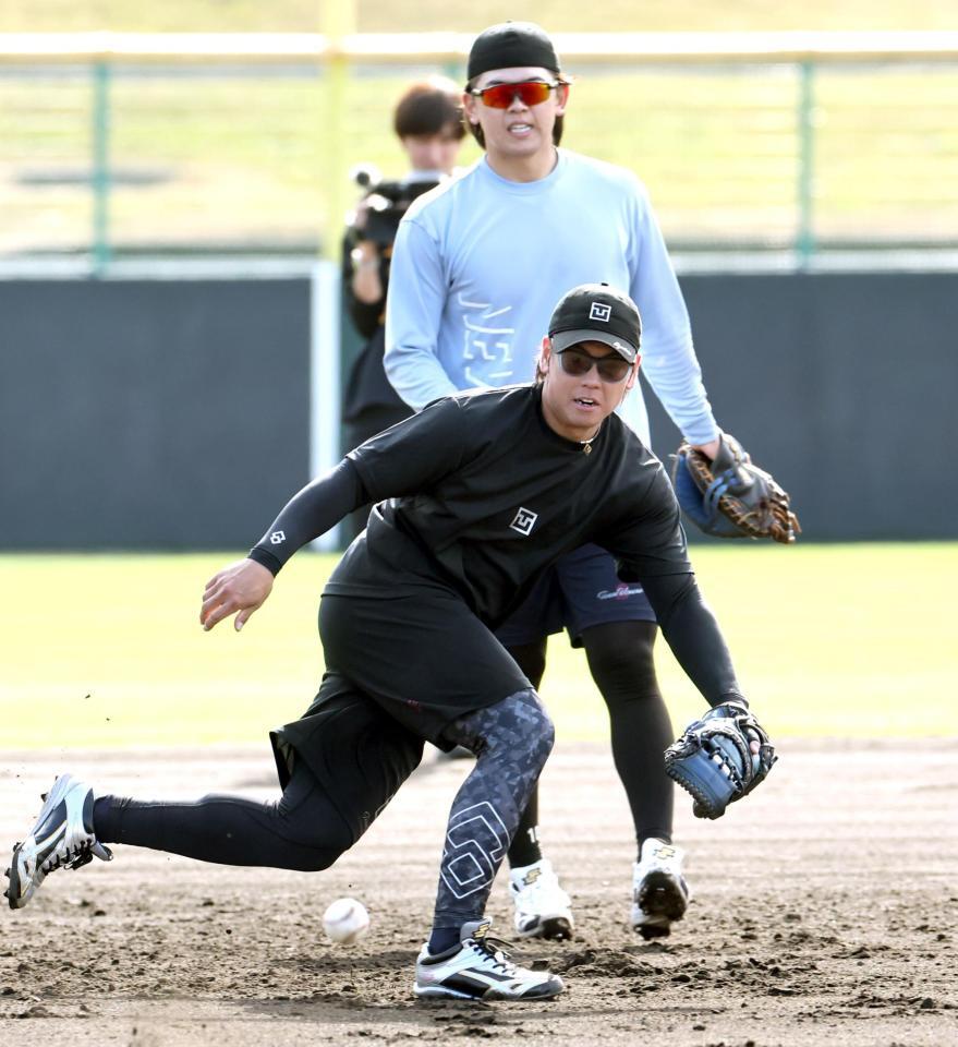ノックを受ける阪神・梅野隆太郎。奥は日本ハム・清水優心＝宜野座（撮影・田中太一）
