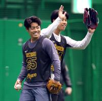 練習中、笑顔を見せる谷端（右は阪神・岡城快生）＝撮影・山口登