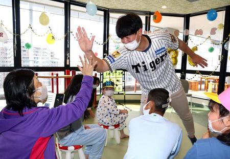 　入院患者らを激励しハイタッチをする畠（撮影・山口登）