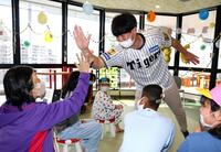 　入院患者らを激励しハイタッチをする畠（撮影・山口登）